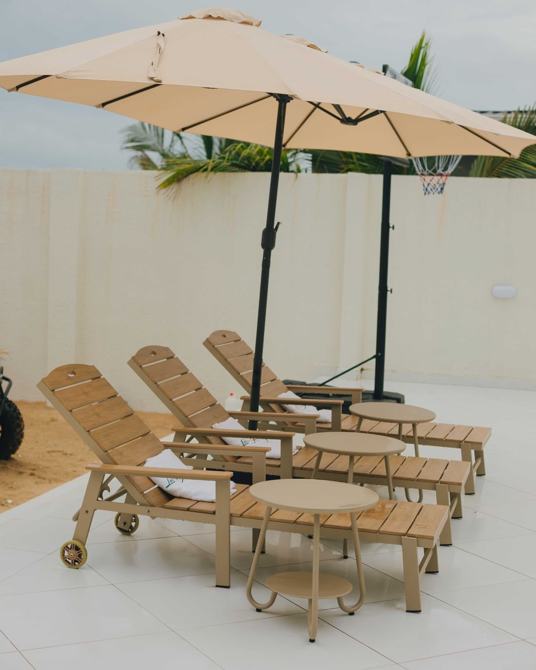 Teak loungers beneath a wide parasol