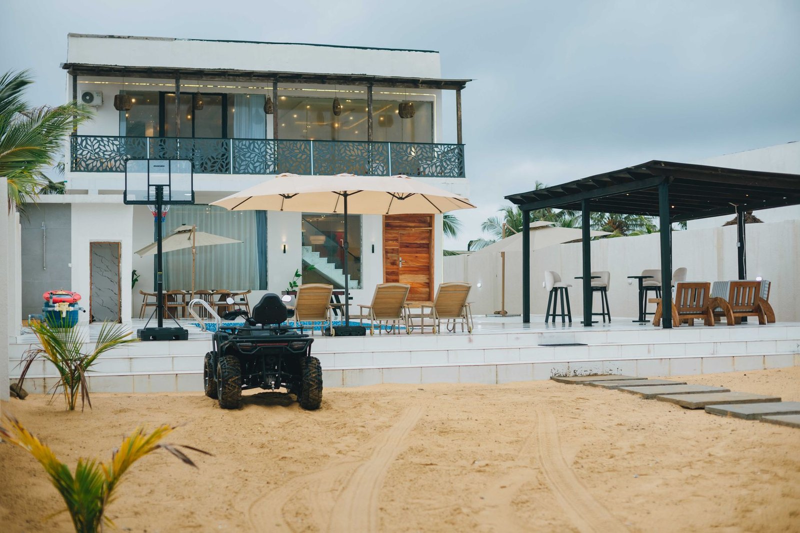La Cream Beach Resort seen from the sand, a two-storey white villa with parasols and loungers